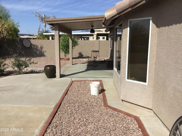 view of patio / terrace with a ceiling fan and fence