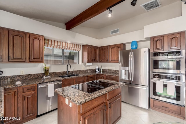 kitchen featuring light tile patterned floors, appliances with stainless steel finishes, a sink, and visible vents