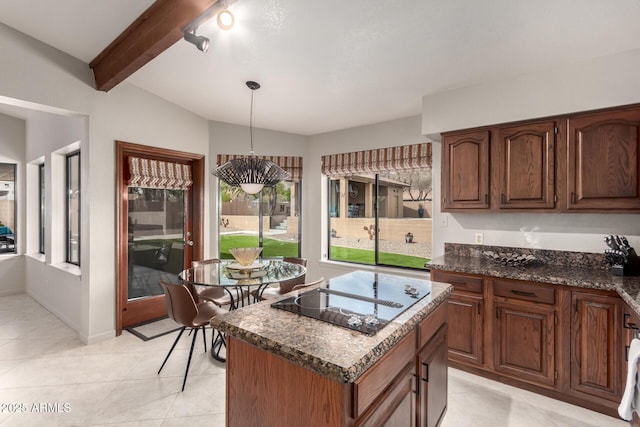 kitchen featuring black electric stovetop, light tile patterned flooring, a center island, beamed ceiling, and pendant lighting