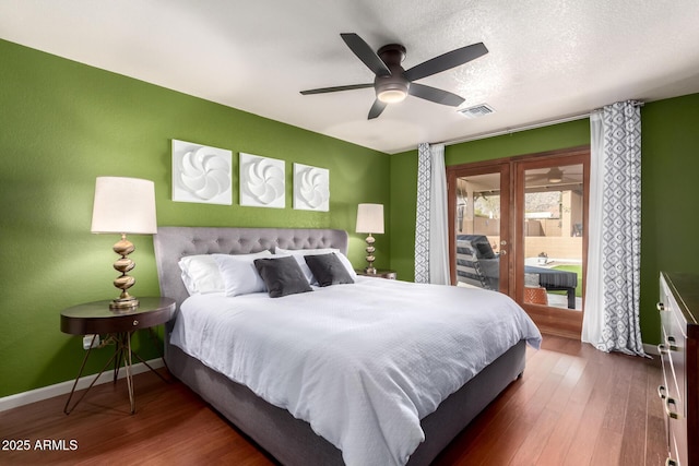 bedroom with visible vents, baseboards, a ceiling fan, wood finished floors, and a textured ceiling