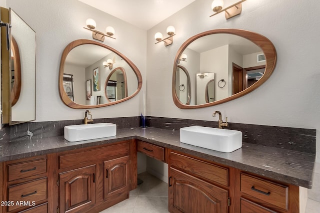 bathroom with double vanity, a sink, and tile patterned floors