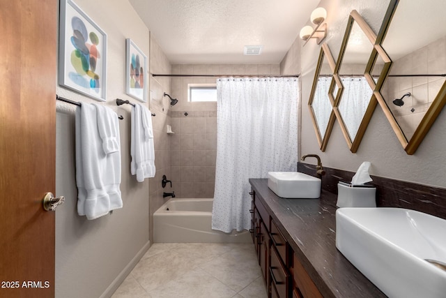 bathroom featuring tile patterned flooring, visible vents, a sink, and a textured ceiling