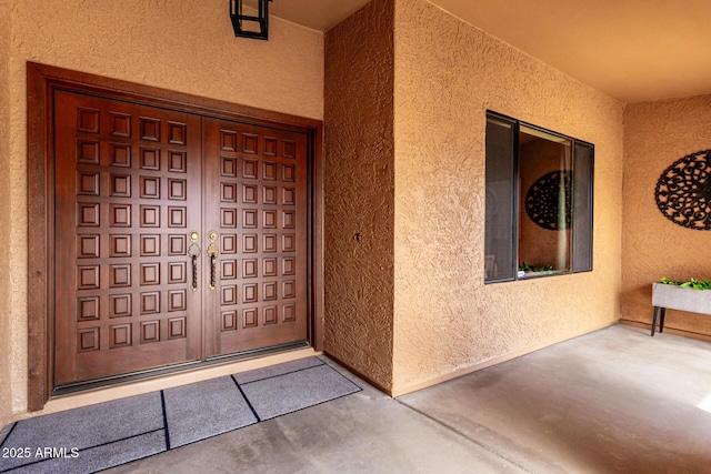 view of exterior entry featuring stucco siding