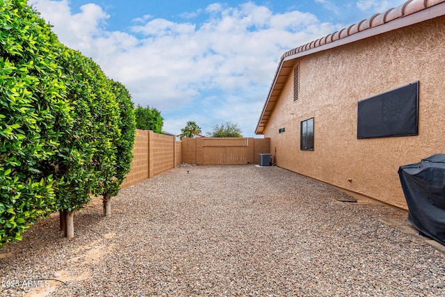 view of yard with a patio area, fence, and central air condition unit