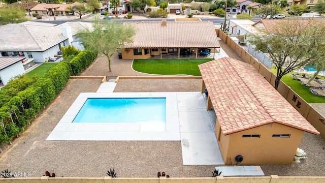 view of pool with a fenced backyard, a residential view, a patio, and a yard