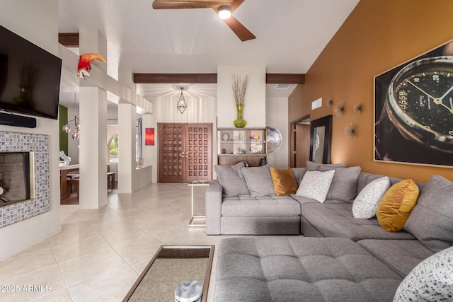 living room featuring ceiling fan, a fireplace, beamed ceiling, and tile patterned floors