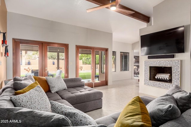 living room with a ceiling fan, a tiled fireplace, vaulted ceiling with beams, french doors, and light tile patterned flooring