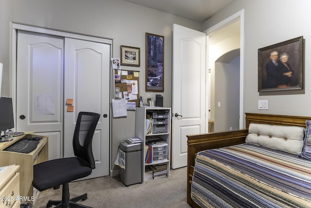 bedroom featuring light colored carpet and a closet