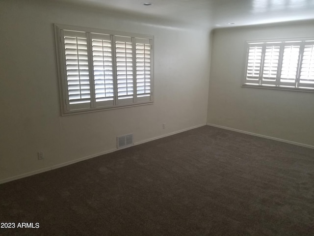 empty room featuring dark carpet