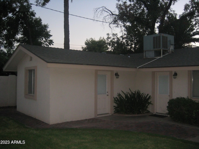 view of front facade featuring a yard and central AC