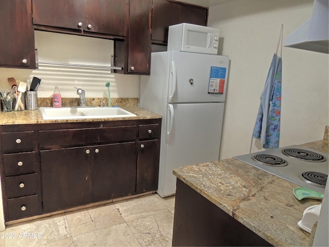 kitchen featuring white appliances, sink, range hood, dark brown cabinets, and light stone counters