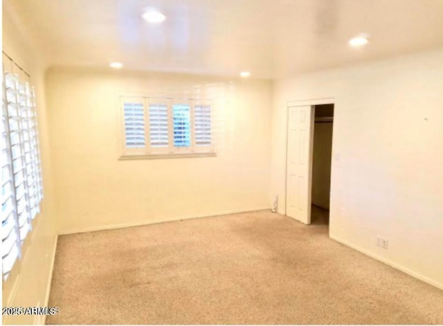 unfurnished room featuring light carpet