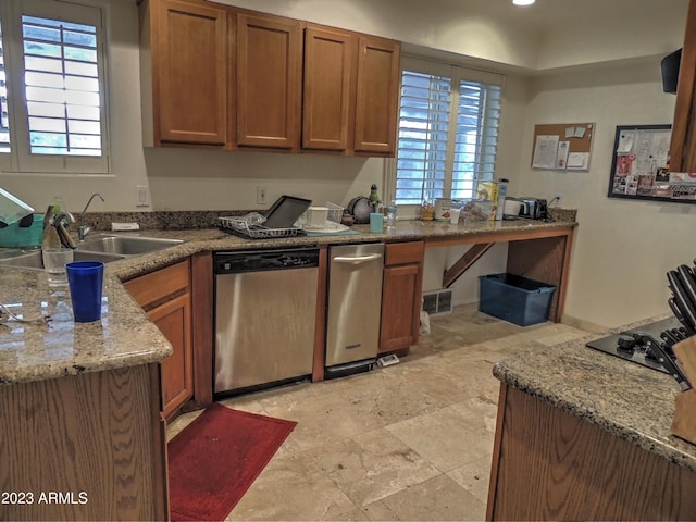 kitchen with dishwasher, light stone countertops, and sink