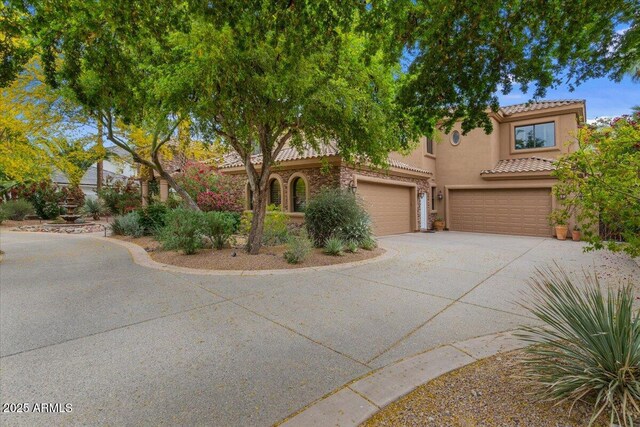 11821 S Tuzigoot Ct, Phoenix, AZ 85044 - mediterranean / spanish house featuring a tiled roof, a garage, stucco siding, and driveway