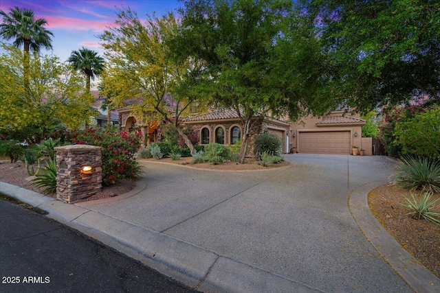 11821 S Tuzigoot Ct, Phoenix, AZ 85044 - mediterranean / spanish house featuring an attached garage, a tiled roof, driveway, and stucco siding