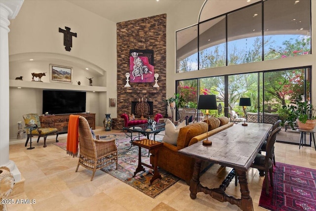11821 S Tuzigoot Ct, Phoenix, AZ 85044 - living area featuring built in features, a stone fireplace, decorative columns, and a high ceiling