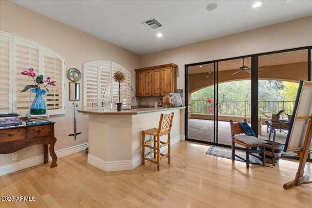 11821 S Tuzigoot Ct, Phoenix, AZ 85044 - kitchen with brown cabinetry, light wood-style floors, baseboards, and visible vents