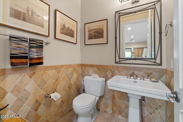 11821 S Tuzigoot Ct, Phoenix, AZ 85044 - half bath featuring a wainscoted wall, tile walls, and toilet