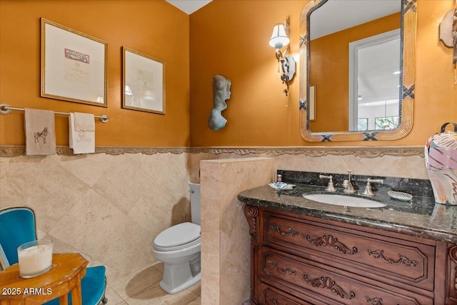 11821 S Tuzigoot Ct, Phoenix, AZ 85044 - half bathroom featuring vanity, tile patterned floors, toilet, wainscoting, and tile walls