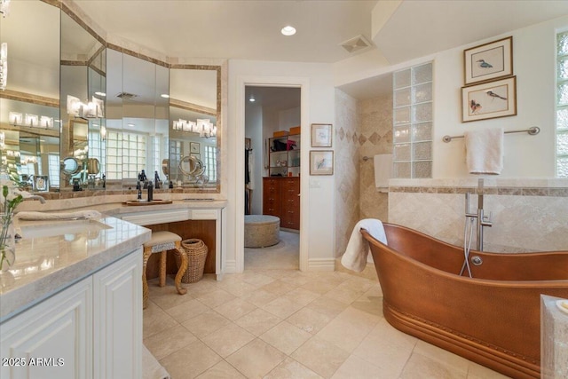 11821 S Tuzigoot Ct, Phoenix, AZ 85044 - full bath with visible vents, a freestanding bath, a walk in closet, vanity, and tile patterned floors