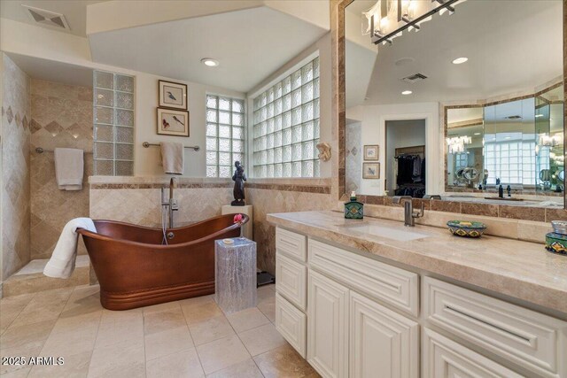 11821 S Tuzigoot Ct, Phoenix, AZ 85044 - full bathroom with a soaking tub, vanity, visible vents, tile walls, and tile patterned floors