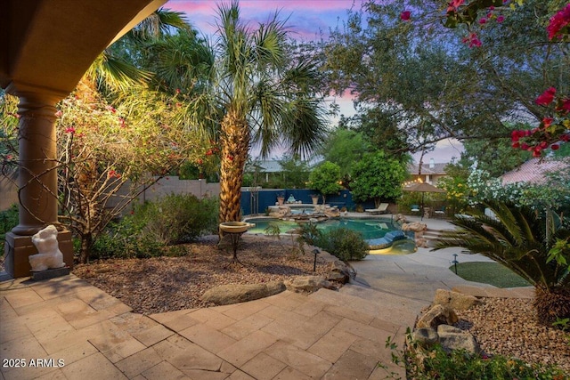 11821 S Tuzigoot Ct, Phoenix, AZ 85044 - pool at dusk featuring a patio area, a fenced backyard, and a pool with connected hot tub