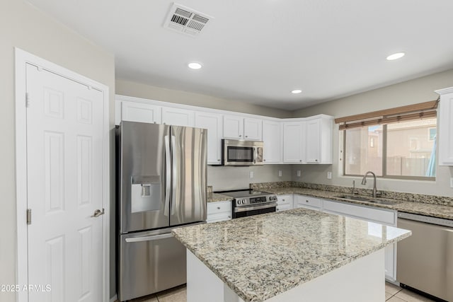 3910 W Goldmine Mountain Dr, San Tan Valley, AZ 85144 - kitchen featuring stainless steel appliances, white cabinets, light stone countertops, a kitchen island, and light tile patterned floors