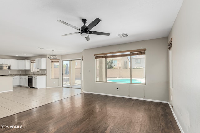 3910 W Goldmine Mountain Dr, San Tan Valley, AZ 85144 - unfurnished living room with a ceiling fan and light wood-style floors