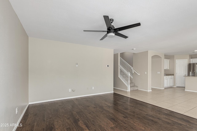 3910 W Goldmine Mountain Dr, San Tan Valley, AZ 85144 - unfurnished living room with a ceiling fan, stairway, and light wood-type flooring