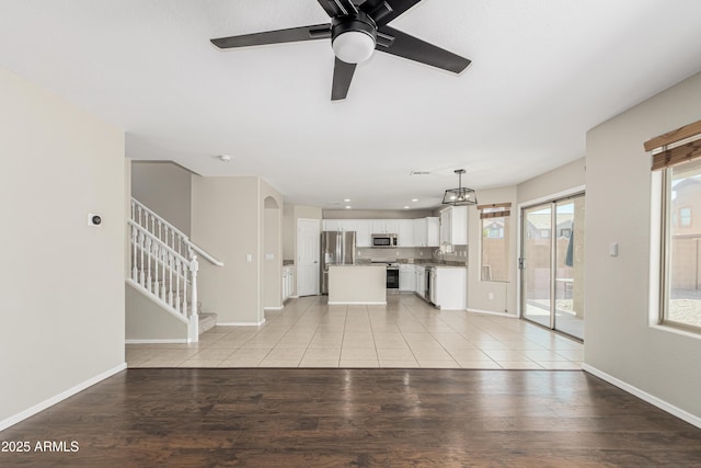 3910 W Goldmine Mountain Dr, San Tan Valley, AZ 85144 - unfurnished living room featuring stairs, ceiling fan, and light wood finished floors
