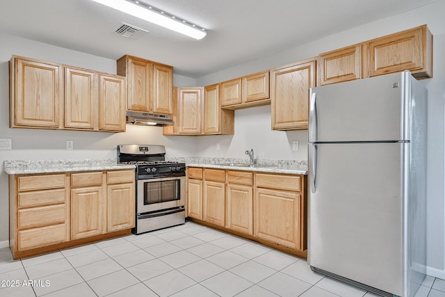 kitchen featuring visible vents, light brown cabinets, under cabinet range hood, a sink, and stainless steel appliances