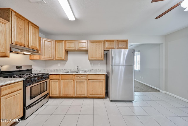 kitchen with ceiling fan, appliances with stainless steel finishes, a sink, light brown cabinets, and under cabinet range hood