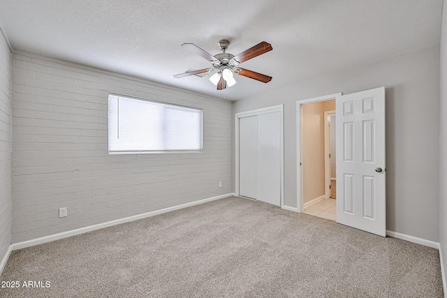 unfurnished bedroom with carpet floors, baseboards, ceiling fan, and a closet