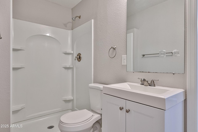 full bathroom featuring vanity, a textured wall, walk in shower, and toilet