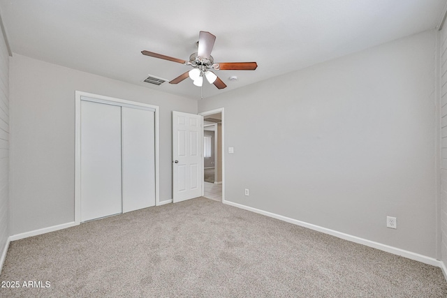 unfurnished bedroom featuring visible vents, carpet floors, a closet, baseboards, and a ceiling fan
