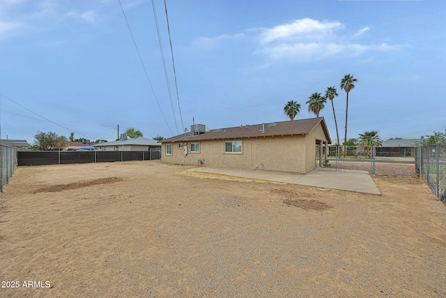 back of property with a fenced backyard, a gate, and stucco siding