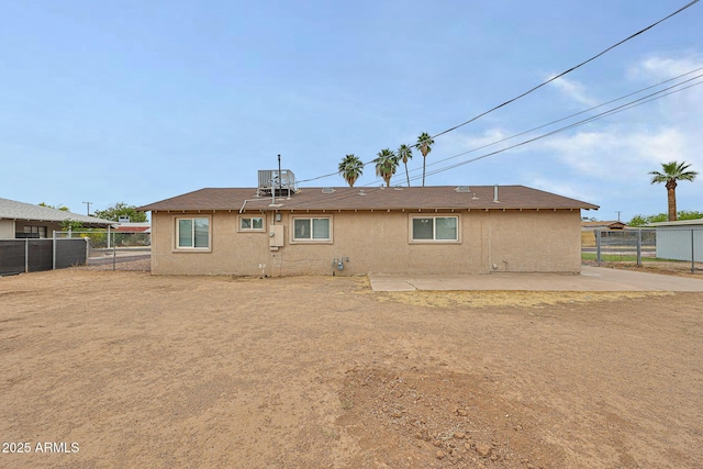 rear view of house featuring stucco siding, fence, central air condition unit, and a patio