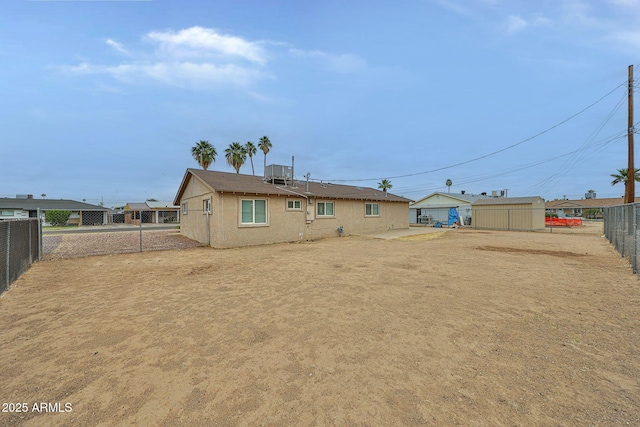 back of property featuring a fenced backyard and stucco siding