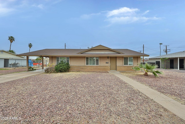 ranch-style house featuring fence, a carport, concrete driveway, and brick siding