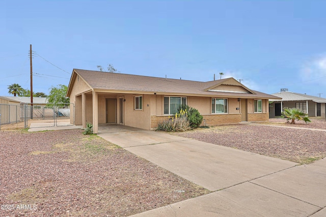 single story home with fence, brick siding, a gate, a carport, and driveway