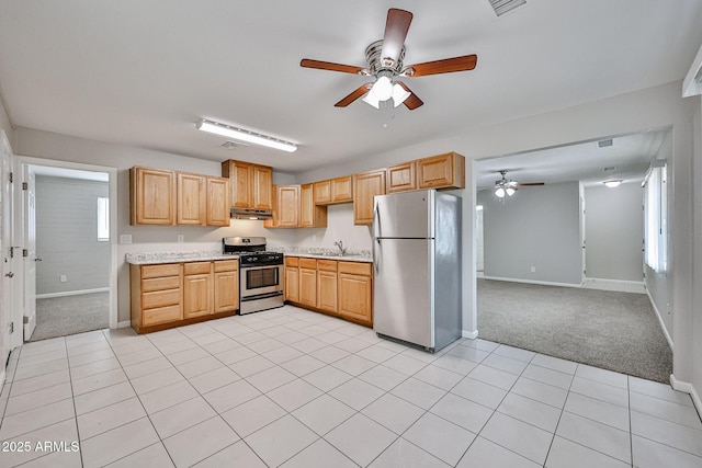 kitchen with a ceiling fan, light countertops, baseboards, under cabinet range hood, and stainless steel appliances