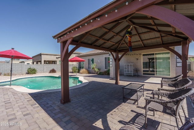 view of pool with a gazebo, fence, a fenced in pool, and a patio