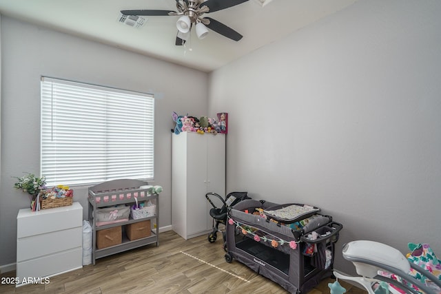 playroom featuring visible vents, a ceiling fan, and wood finished floors