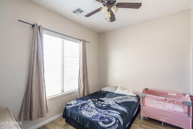 bedroom featuring multiple windows, wood finished floors, visible vents, and baseboards