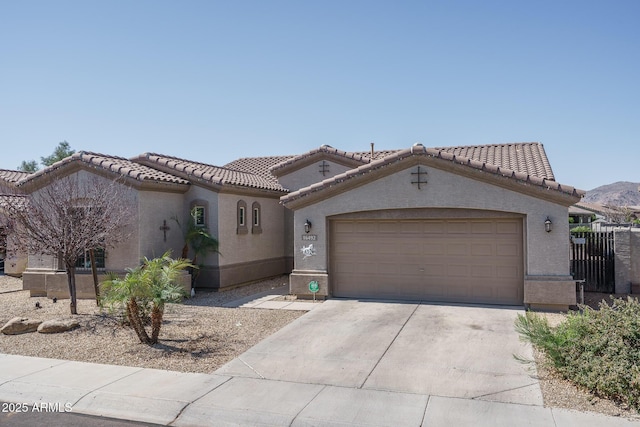 mediterranean / spanish-style home featuring stucco siding, a garage, driveway, and a tile roof