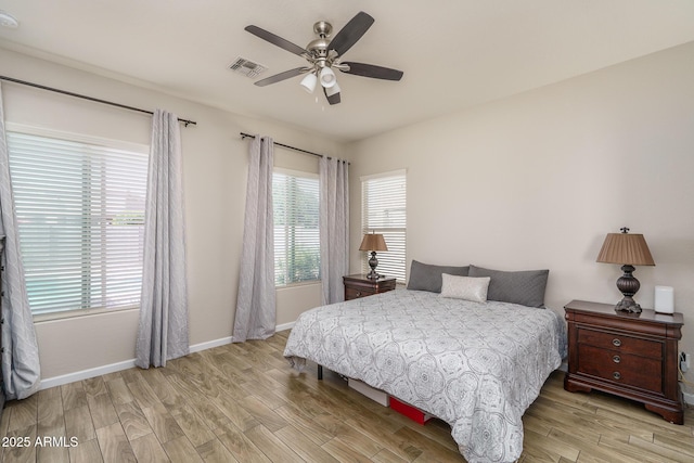 bedroom featuring visible vents, a ceiling fan, baseboards, and wood finished floors