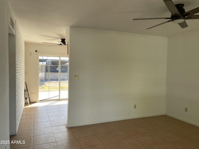 tiled spare room with brick wall, ceiling fan, and a brick fireplace