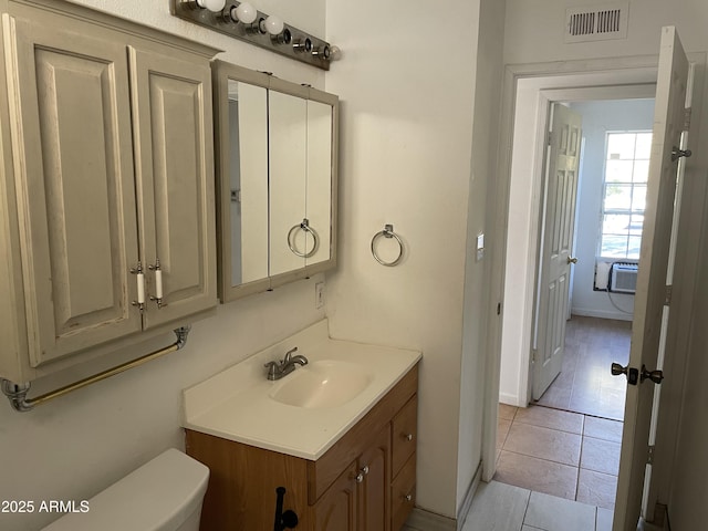 bathroom with cooling unit, tile patterned floors, toilet, and vanity