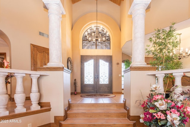 entrance foyer featuring a notable chandelier, french doors, and ornate columns