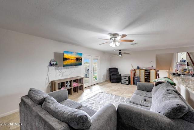 living area with a textured ceiling, french doors, light tile patterned floors, and visible vents